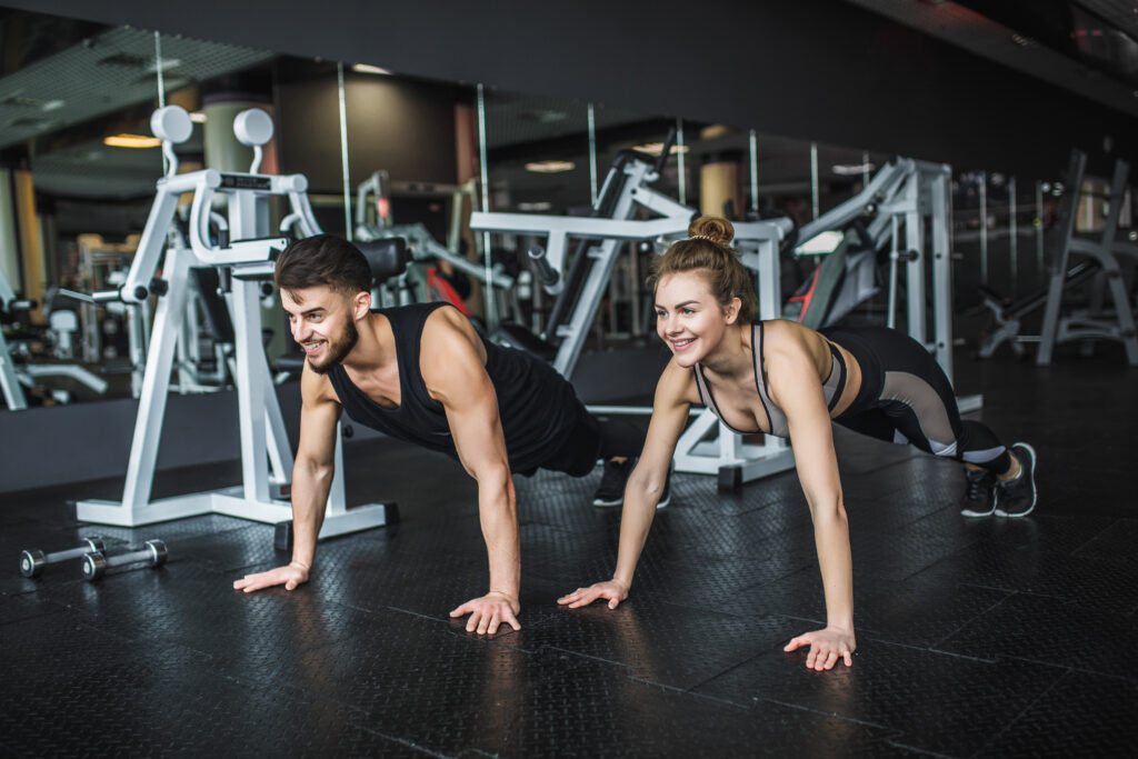 Motivated Young Blond Woman And Man In Middle Of Workout, Standi